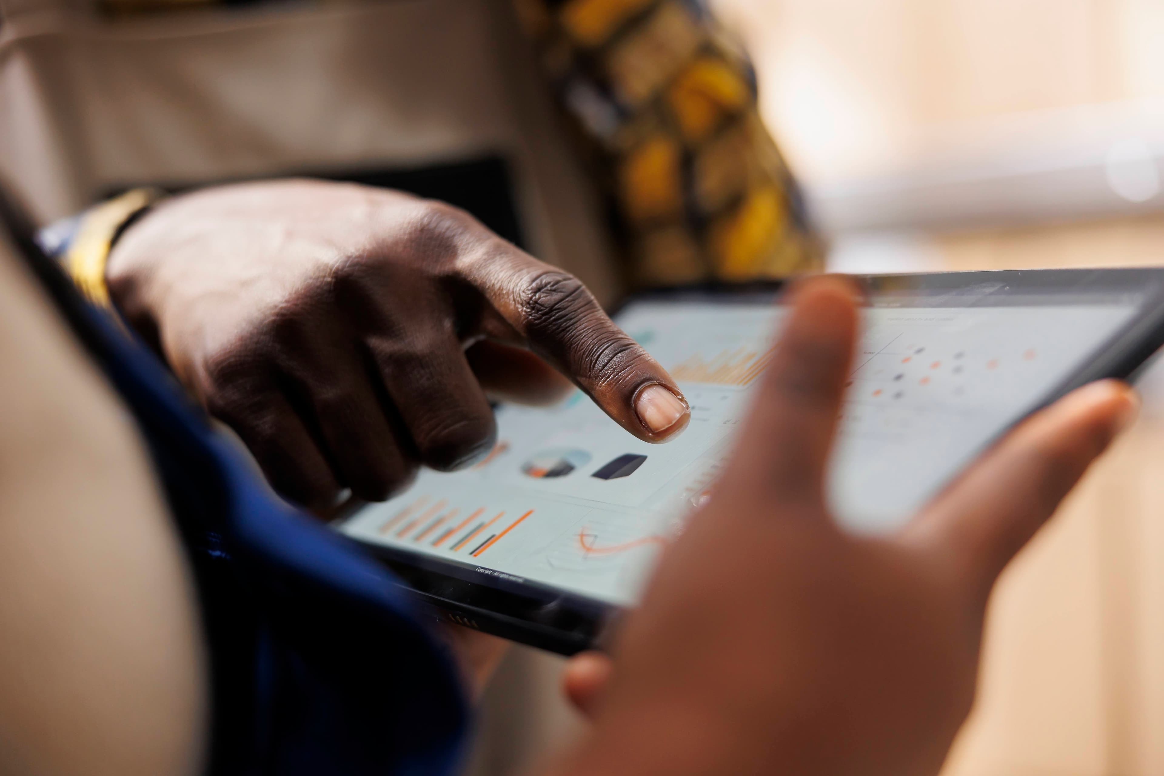 Warehouse worker pointing to inventory and operations analytics on tablet screen